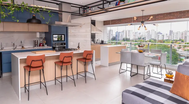 Cozinha integrada com ilha branca, banquetas laranja e vista da cidade