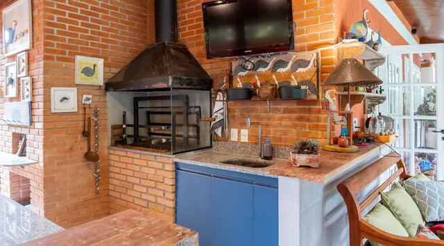 Espaço gourmet com parede de tijolos e armários azuis